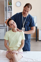 Vertical image of doctor in uniform massaging patient at hospital