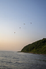 Paraglider flying in the blue sky