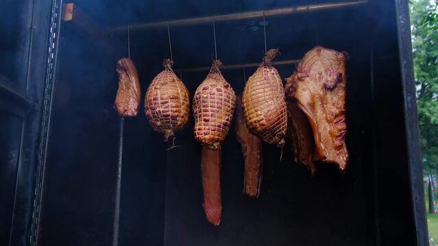 Pork belly and ribs and hams being smoked in home build smoker made of tool box and other scarp materials.