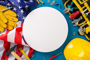 Labor Day tribute: A captivating top-view image showcasing the American flag, construction helmet, work gloves, and tools on blue background. Perfect for Labor Day promotions or text placement
