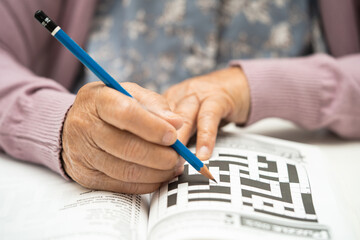 Alzheimer disease AD, Asian elderly woman playing sudoku puzzle game to practice brain training for...