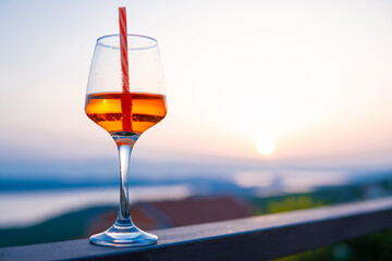 glass with a drink on vacation at sunset. Relax in the apartment