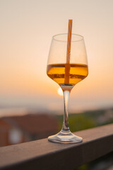 glass with a drink on vacation at sunset. Relax in the apartment