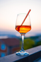 glass with a drink on vacation at sunset. Relax in the apartment
