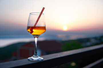 glass with a drink on vacation at sunset. Relax in the apartment