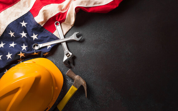 Happy Labor day concept. American flag with different construction tools on dark background. - Powered by Adobe
