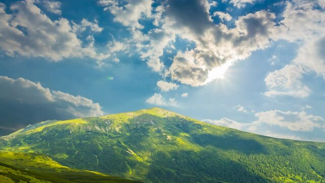  green mountain under cloudy sky at the summer day time lapse scene