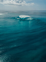 Naklejka premium Glassy wave with barrel in blue ocean in Bali. Aerial view
