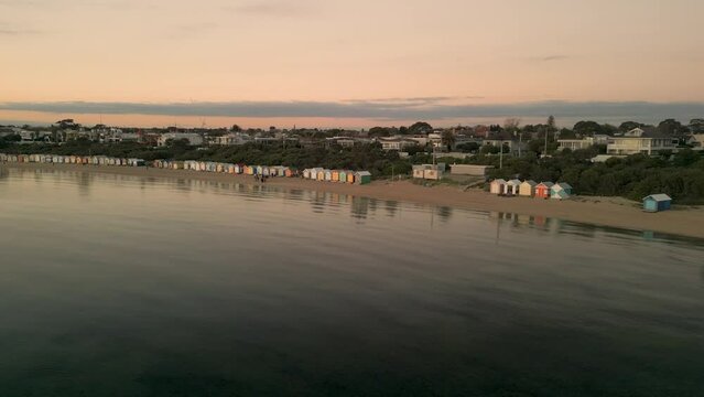 Slow aerial pan along Dendy Street Bathing Boxes, Brighton Beach