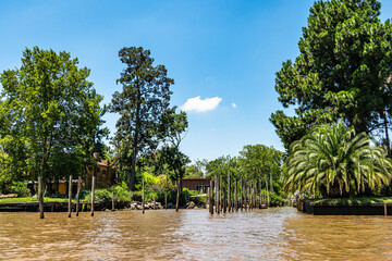 Fototapeta na wymiar Boat tour on the Parana Delta, Tigre, Buenos Aires, Argentina. Palm trees, construction site of modern brick house.