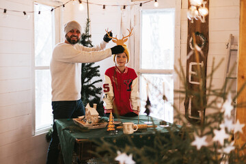 family man father and teenage boy son having fun in living room of cozy winter house, Christmas and New Year holidays and vacation
