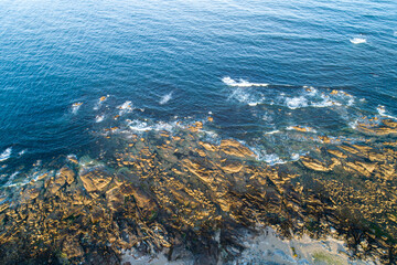 aerial top view of a rocky beach at sunrise