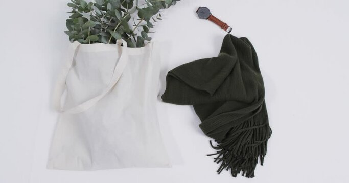 Video of white canvas bag with plant, scarf, watch, copy space on white background