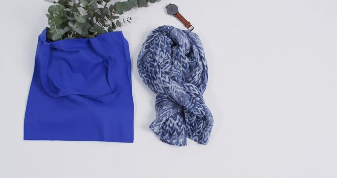 Video of blue canvas bag with plant, scarf, watch, copy space on white background