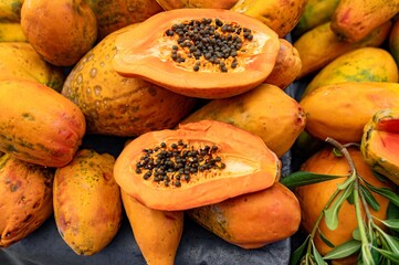 Fresh ripe papaya fruits on wooden table of street market, organic papaya closeup view