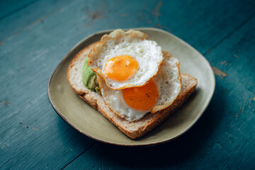 Breakfast toast with avocado, fried egg