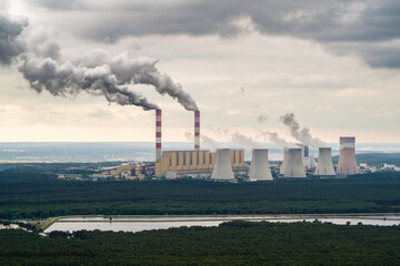 Aerial view of power plant, smoke from chimneys and open-cast coal mine in Belchatow under moody...