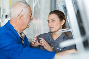 Obraz premium woman and seniro working in a windows factory