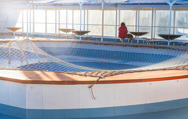 A lonely man in red relaxing at the table of a cruise ship - travel and vacation concept