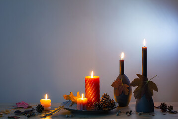 autumn dark decor with candles on wooden shelf on background wall