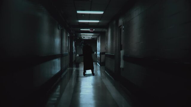 Creepy Ghost Creature Approach Dark Hospital Corridor Spooky Scene. Spooky dark hospital corridor with a ghostly figure approaching camera. Eerie scene
