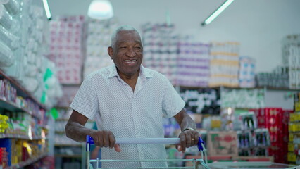 One joyful black Brazilian man pushing shopping cart at grocery store. African American consumer browsing for products to buy, looking at shelves