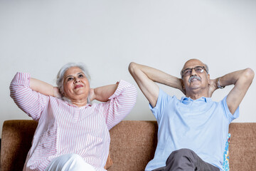 indian senior couple Sitting on sofa at living room and rest on sofa , Retired life goal concept
