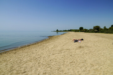 Fototapeta na wymiar lonely girl on the empty sandy beach of Issyk-Kul lake Kyrgystan. High quality photo