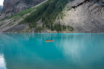 couple canoeing in beautiful glacial Moraine Lake