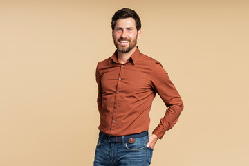 Smiling bearded middle aged businessman, manager looking at camera while posing isolated on beige...