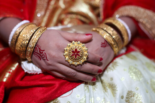 Closeup image of hands of a hindu bride decorated with golden ornaments 