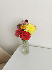 Bright bouquet of flowers on the table in a glass vase.