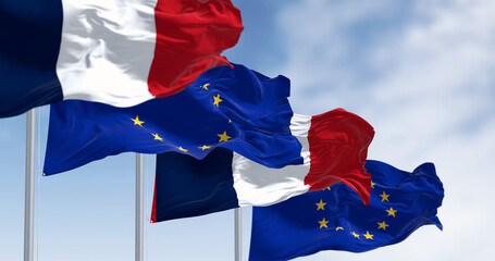 Flags of France and the European Union waving together on a clear day