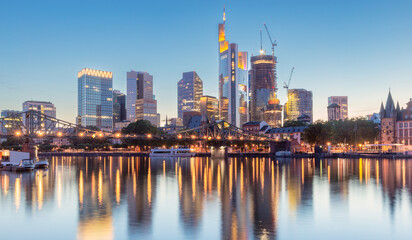 Skyscrapers in Frankfurt am Main against the backdrop of the river at sunset.
