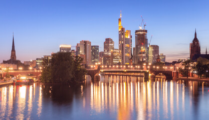 Fototapeta na wymiar Skyscrapers in Frankfurt am Main against the backdrop of the river at sunset.