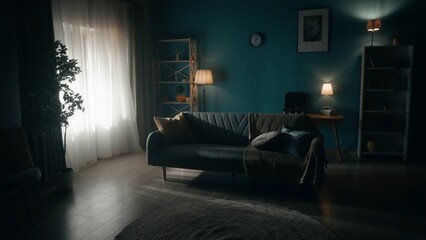 The interior of a dark room illuminated by the rays of the setting sun. The day is coming to an...