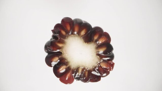 An isolated blackberry on a white background rotates in close-up view.