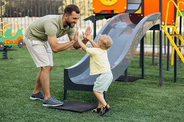 Father with son going down the slide on the playground