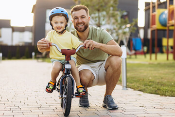 Father teaching his little son to ride a bicycle