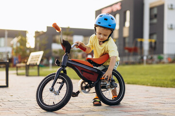Cute little boy learning to ride a bicycle