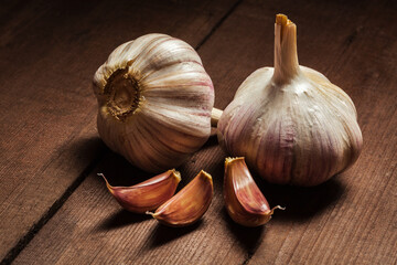 Garlic and cloves close up on old wooden background