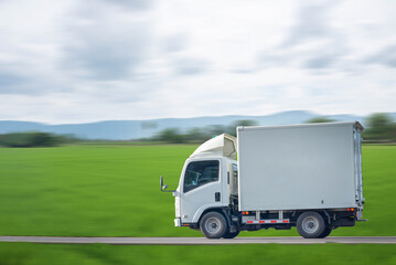 Side view of a small truck driving on a country road, truck running on the road, small truck on the...