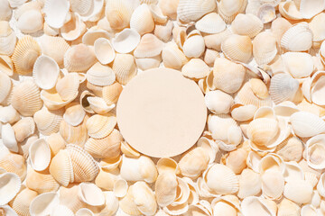 Summer cosmetics product presentation scene made with round podium on seashells background.