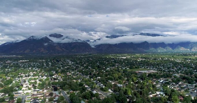Aerial 4k view of the Wasatch Mountains and sprawling neighborhoods in the summer