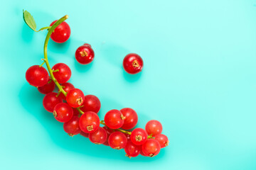 Red currant berries on turquoise background, top view. Fresh and juicy organic redcurrant berry macro shot. Tasty vegan food on blue backdrop 