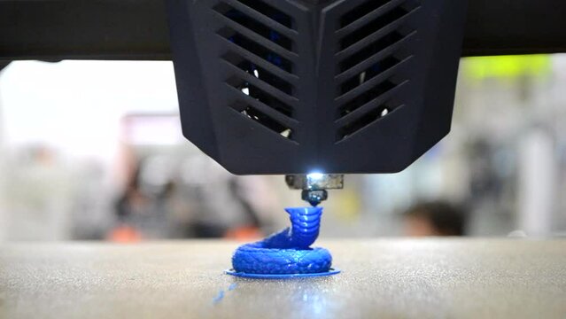 3D printer printing prototype of toy from molten plastic. Fast process creating model of toy on 3D printer from blue melted plastic close-up. Additive new printer technology. Modern printing timelapse