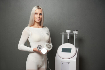 Woman showing the attachments of a beauty machine for rf lifting and vacuum massage