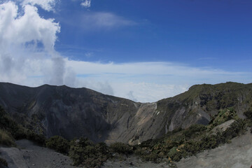 Volcanic landscape on the top of the crater with clouds at the Irazú Volcano National Park