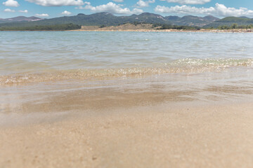 Golden sand and crystal clear sea water on the beach. Seascape, summer background.