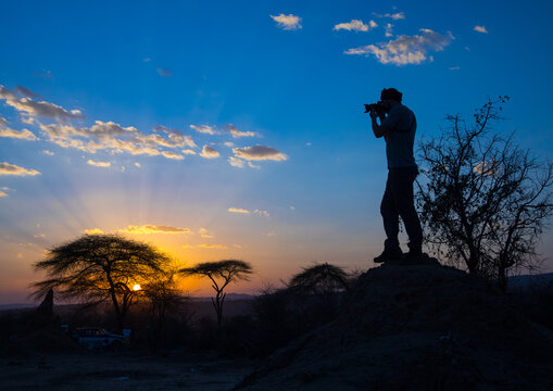 Photographer taking pictures at sunset, Oromia, Yabelo, Ethiopia